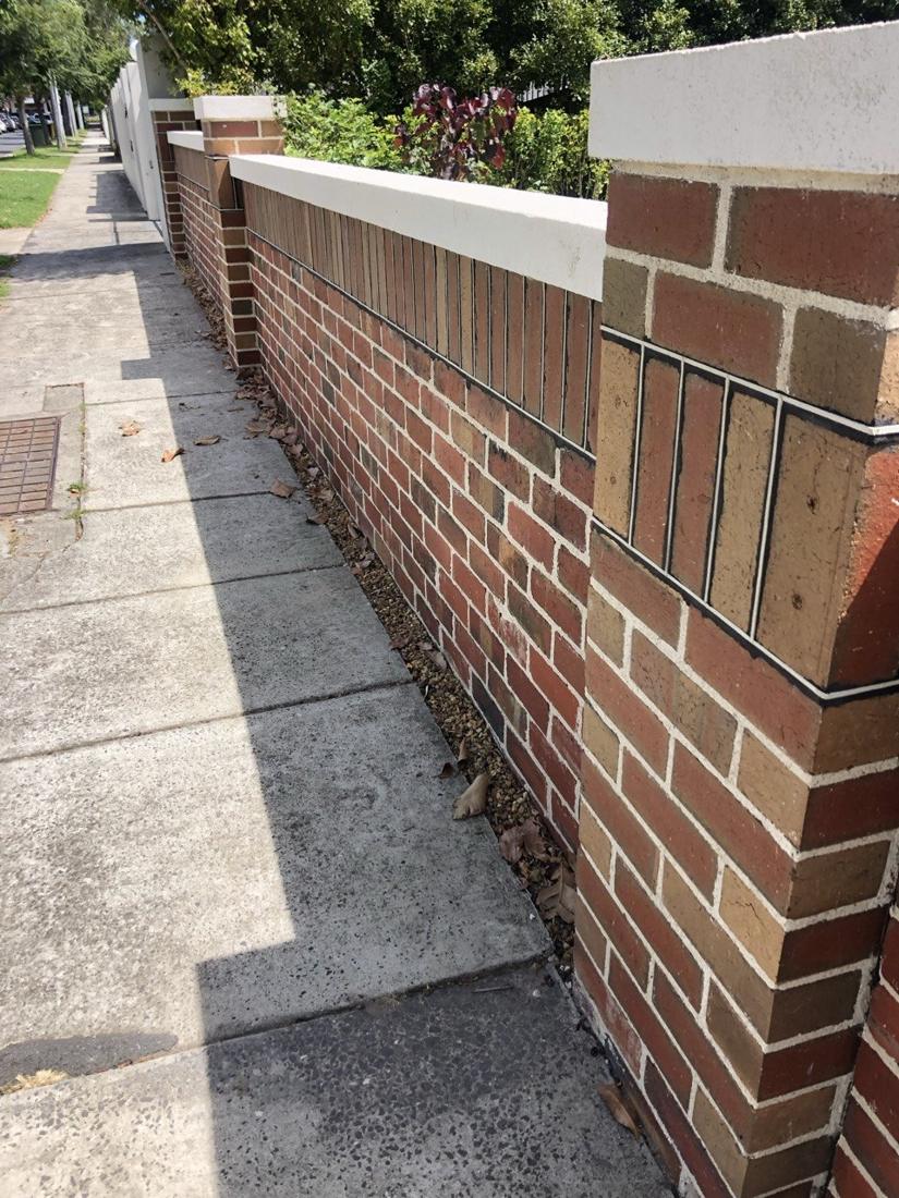 Red and tan brick front fence with piers, rendered capping and a vertical brick feature band