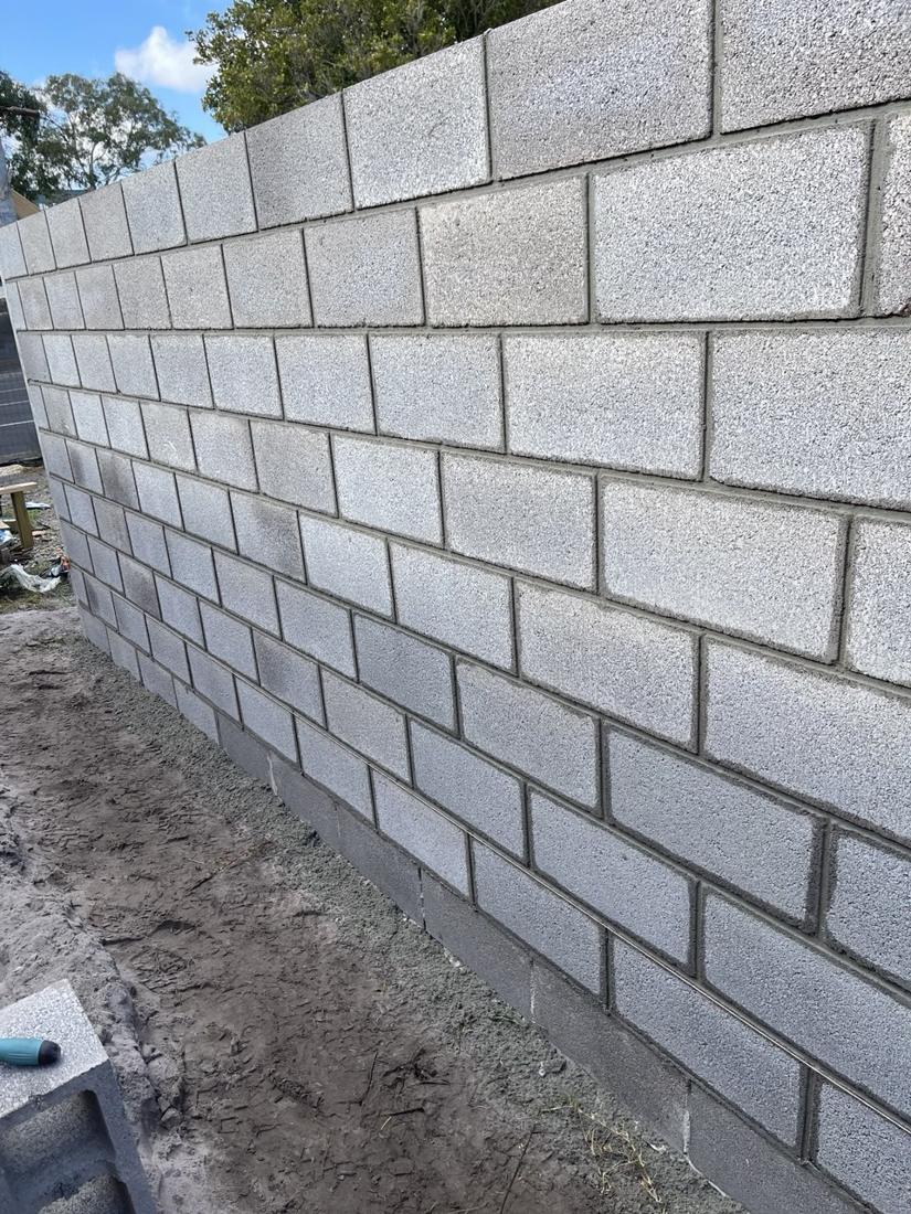 Long concrete blockwork boundary wall with neat struck joints